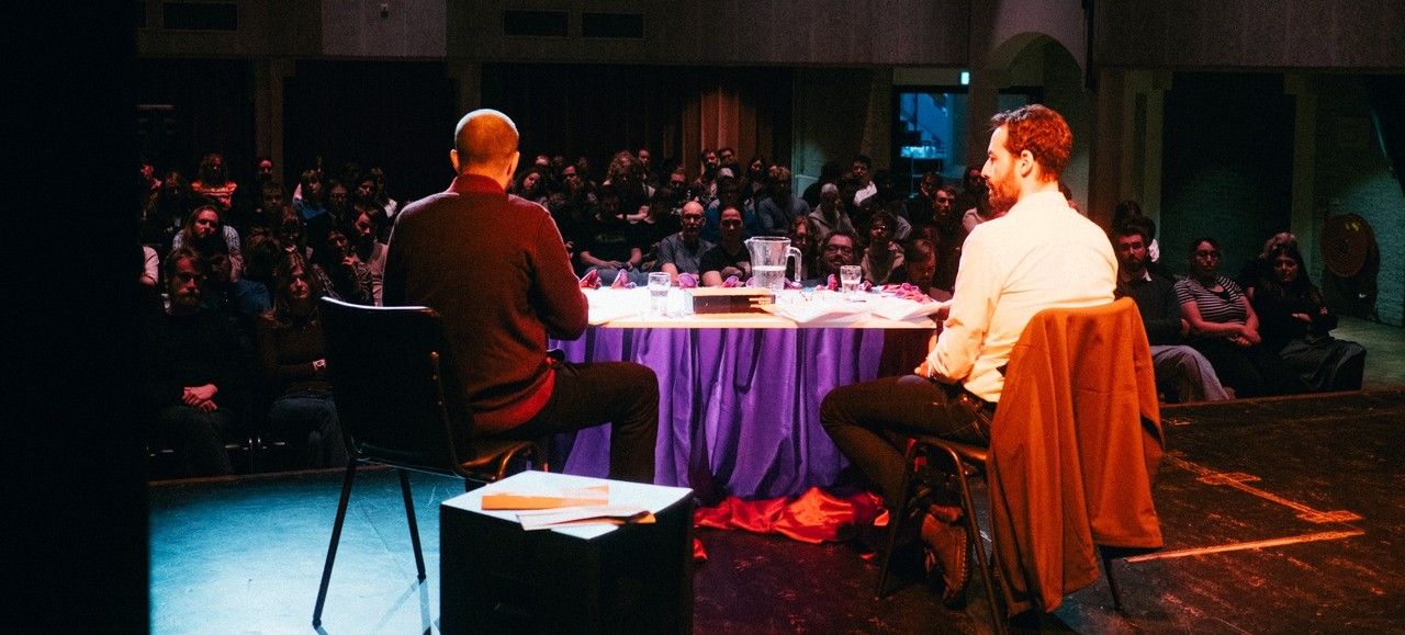 Interview op een podium voor een volle zaal