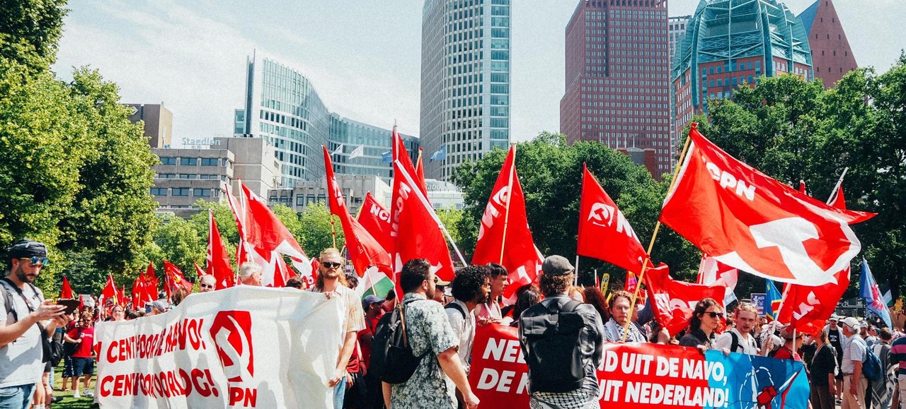 Protest with red flags and banners against the NATO summit in The Hague