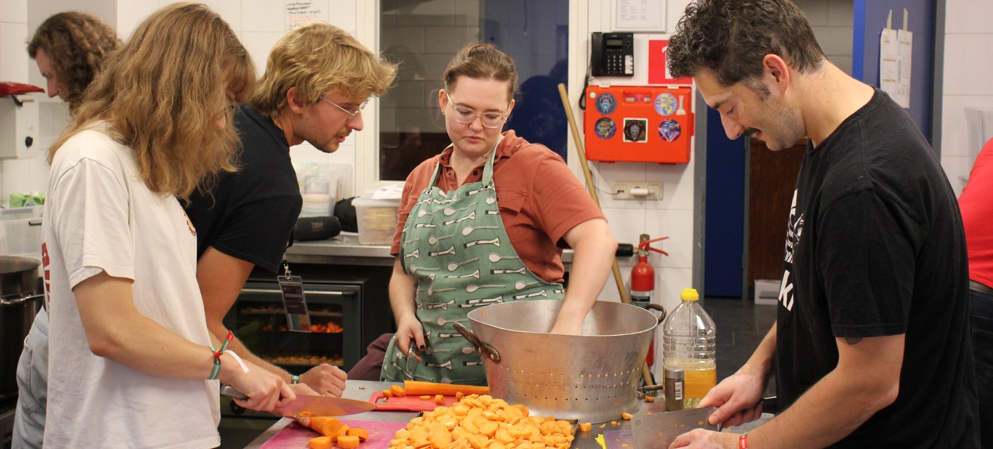 Camp participants chop carrots together in the summer camp kitchen