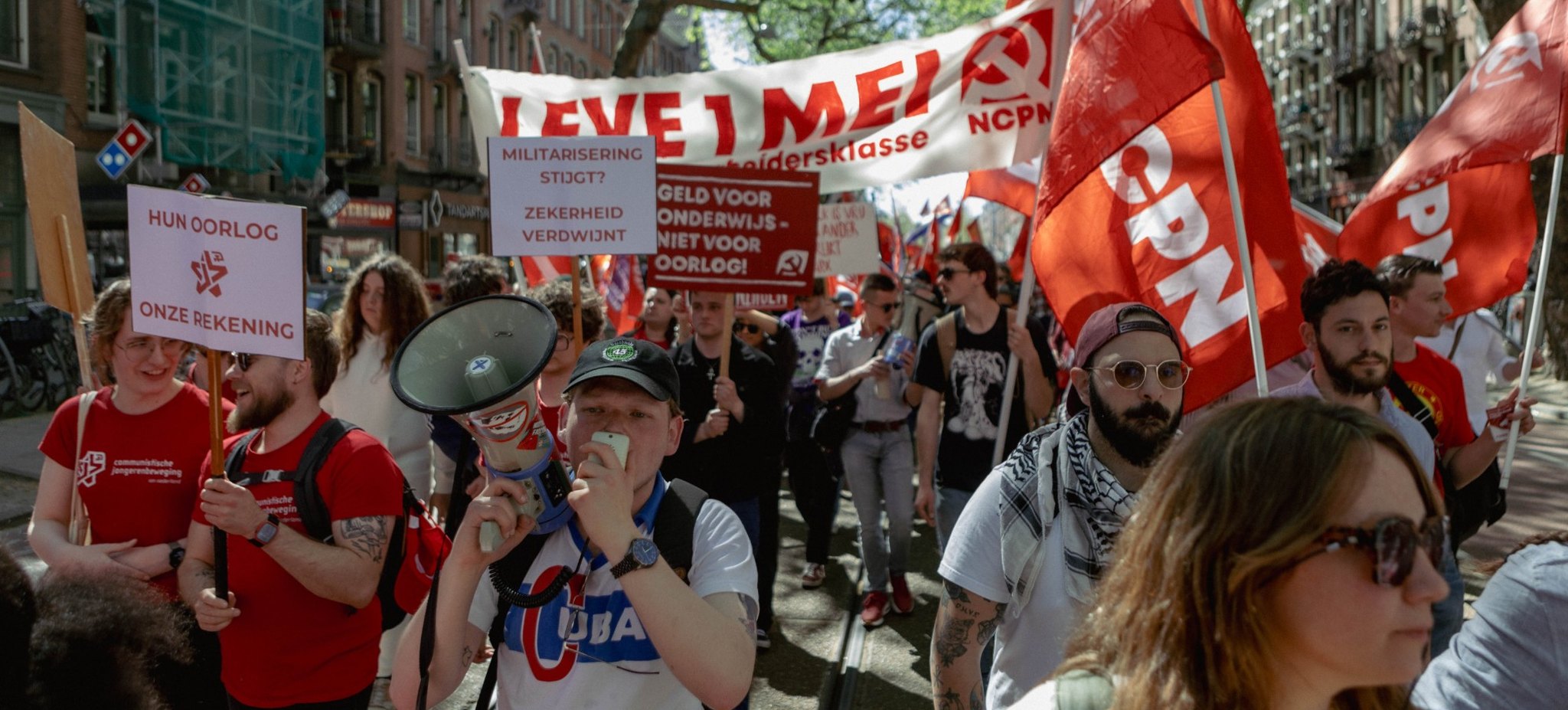 1 mei-demonstratie met CPN-vlaggen en borden tegen militarisering